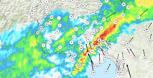 Figura 1. Immagine congiunta della riflettività massima verticale del radar (VMI, in dBZ) e del vento al suolo (in km/h), tratta dal database meteoclimatico OMNIA. Si nota come a sud del sistema temporalesco il vento sia da sud-est sostenuto, mentre a nord del sistema il vento sia scarso e per lo più da nord-ovest. L’immagine si riferisce alle ore 01:00 locali del 17 novembre.